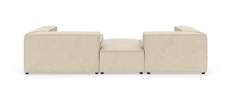 Beige modulsofa set bagfra med lav midterpuf på hvid studiebaggrund.