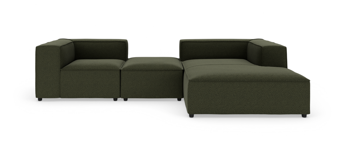 Modulær mørkegrøn hjørnesofa med chaiselong, kubiske armlæn og lav profil på hvid baggrund.