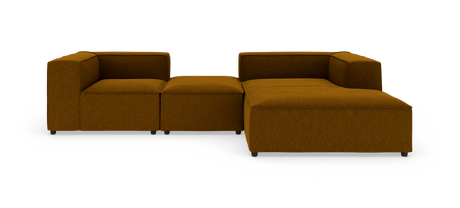 Modulsofa i sennepsgul/brun tekstil på hvid studiebaggrund, L‑form med chaiselong til højre.
