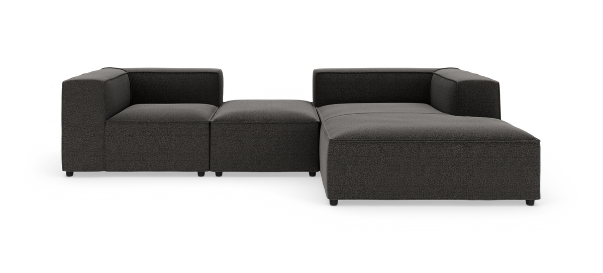 Modulær mørkegrå hjørnesofa med chaiselong i stof, frilagt på hvid baggrund.