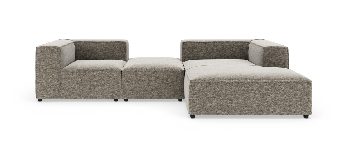 Modulær hjørnesofa i grå‑beige stof med lave armlæn og bred chaiselong.