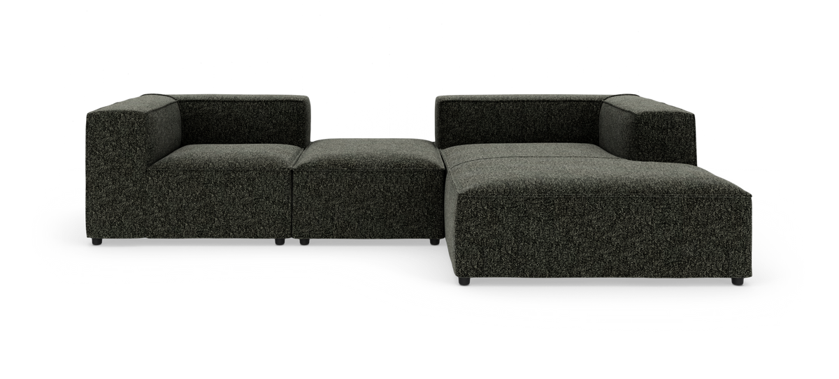 Mørkegrå modulsofa i stof med hjørne- og chaiselongdel, fotograferet lige for i studie.