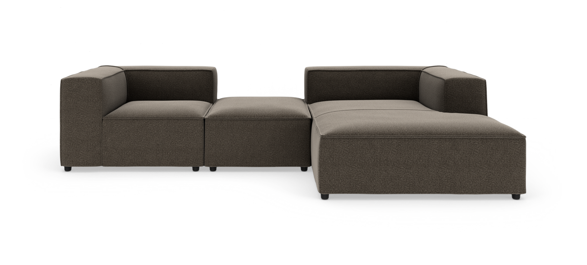 Modulsofa i mørkebrun tekstil, L‑form med chaiselong og midtermodul, frilagt på hvid baggrund.