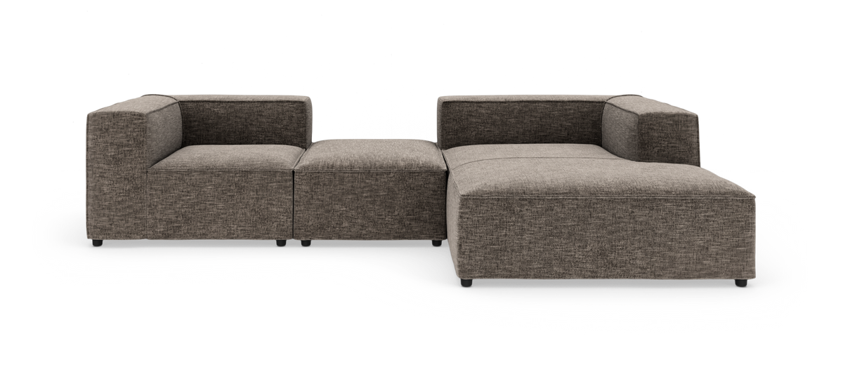 Modulsofa i brunmeleret stof, L-form med bred chaiselong, frilagt på hvid baggrund.