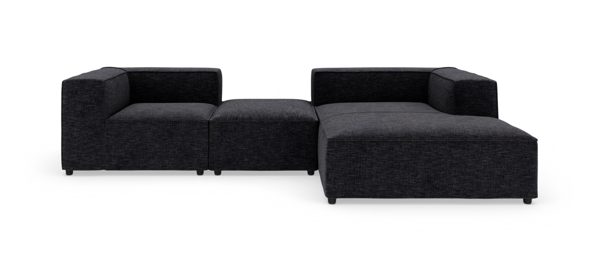 Modulær mørkegrå hjørnesofa i tekstil, vist på hvid studiebaggrund.