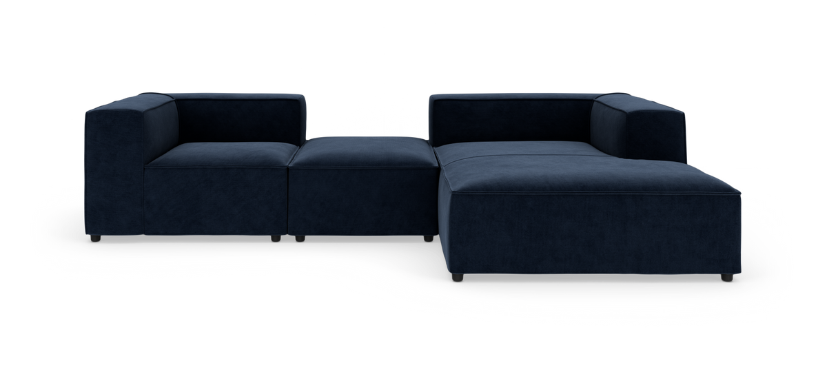 Modulær mørkeblå hjørnesofa med chaiselong på højre side mod hvid baggrund.