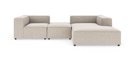 Modulær L‑sofa i beige stof med brede, kantede armlæn og lav profil, fritlagt på hvid baggrund.