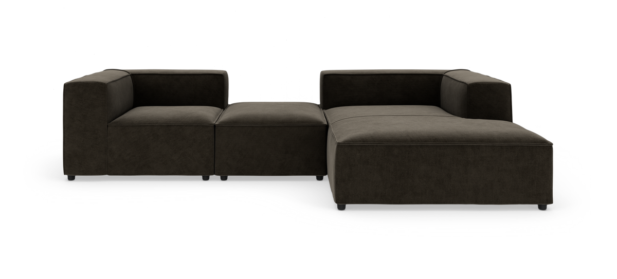 Modulsofa i mørk brunsort tekstil med chaiselong til højre, vist i studie mod hvid baggrund.
