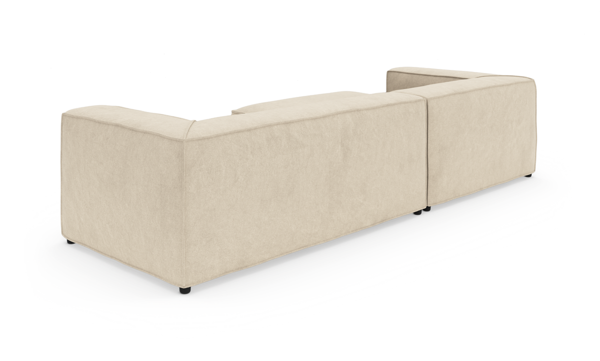 Beige modulsofa i L-form set bagfra på hvid baggrund.