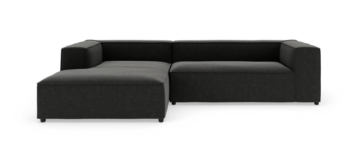 Modulær mørkegrå hjørnesofa med venstrevendt chaiselong i stof, vist på hvid studiobaggrund.