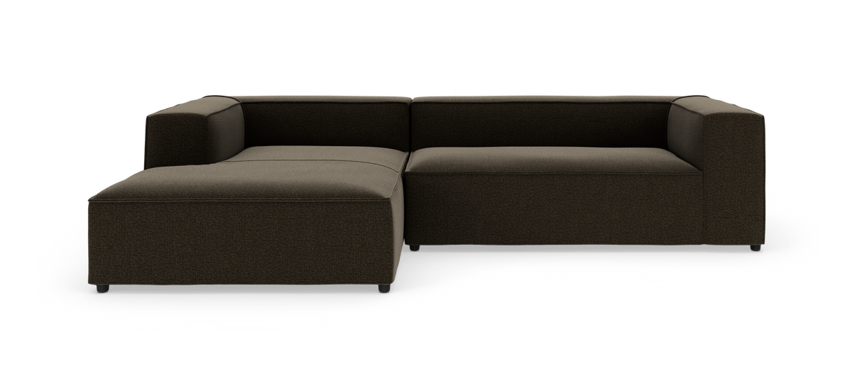 Modulsofa i mørkebrunt stof, L-form med chaiselong til venstre, fotograferet på hvid studiebaggrund.