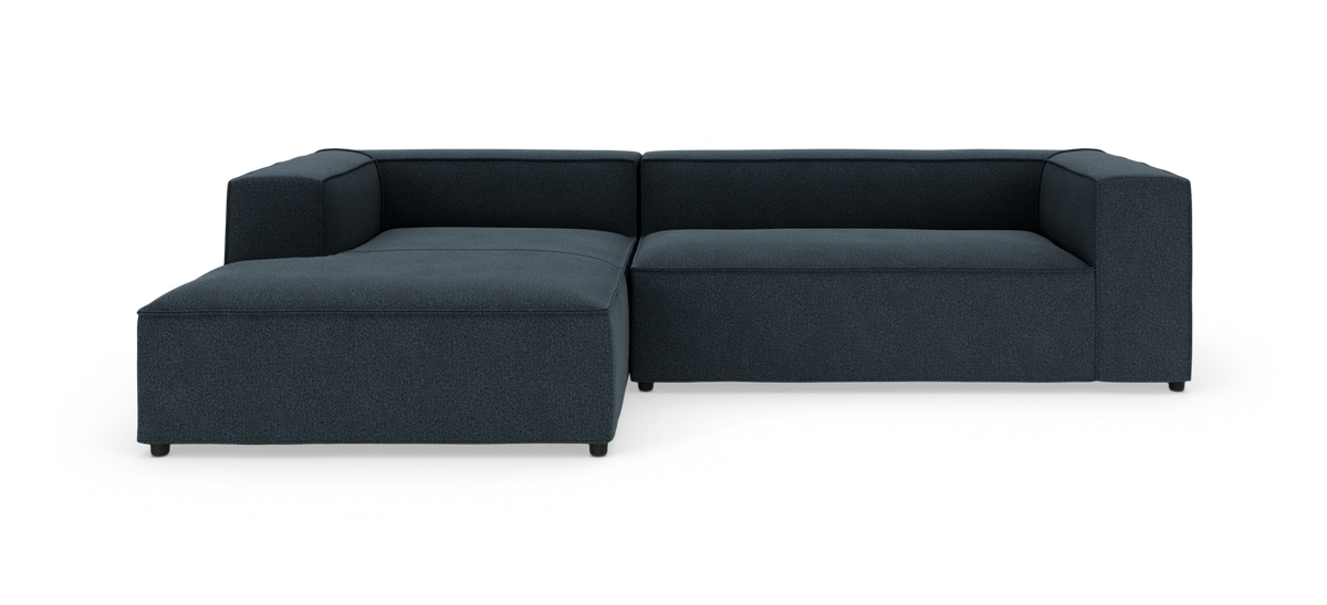 Modulær hjørnesofa i mørk blågrå tekstil med venstrevendt chaiselong, produktbillede på hvid baggrund.