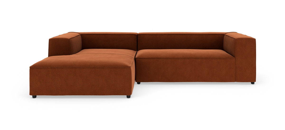 Rustfarvet modul hjørnesofa i stof med venstrevendt chaiselong, moderne kubisk design på hvid studiobaggrund.