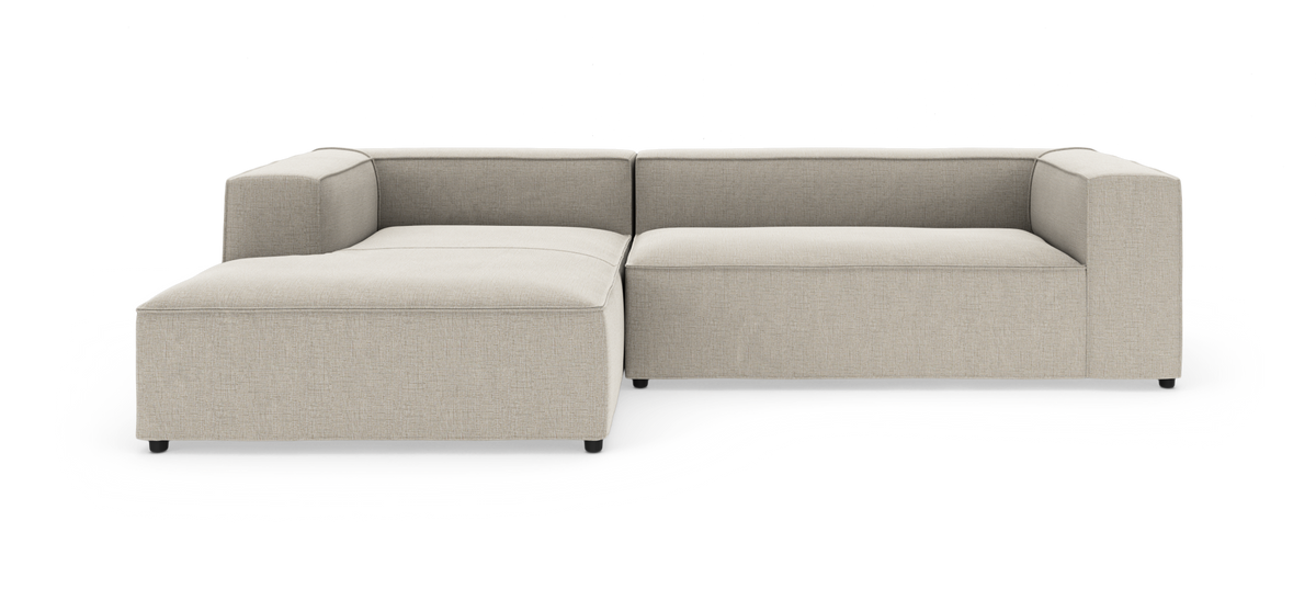 Beige modulsofa i L-form på hvid studiobaggrund.