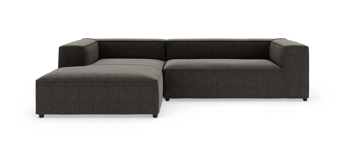 Mørkegrå L‑formet modulsofa på hvid baggrund, vist lige forfra.