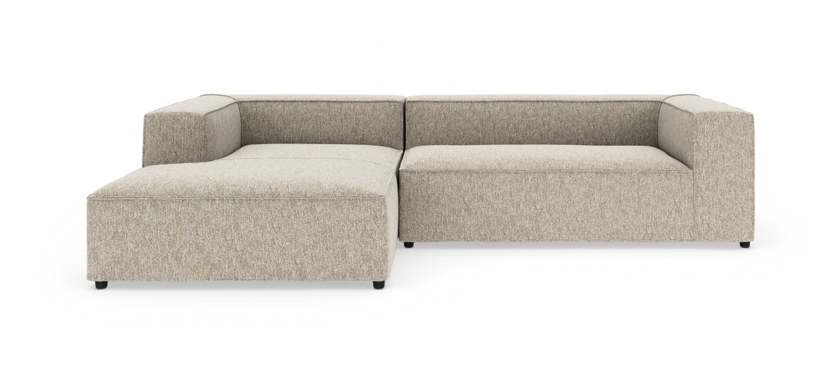 Modulær L‑sofa i beige tekstil med venstrevendt chaiselong, lave blokarmlæn, fritlagt på hvid baggrund, frontvisning.