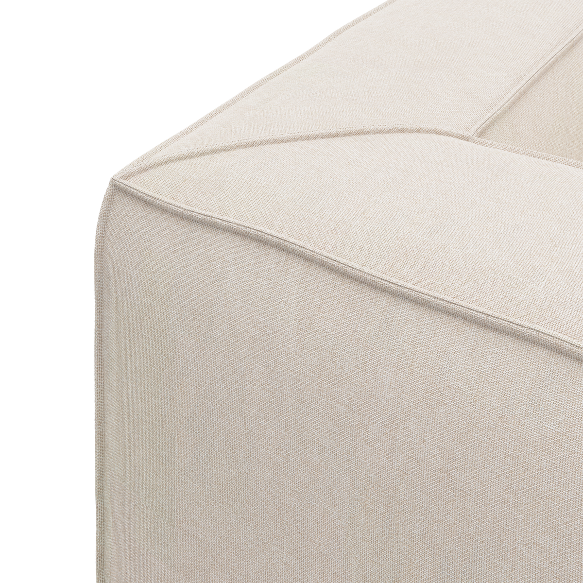 Nærbillede af hjørnet på en beige modulsofa i stof med tydelige syninger, frilagt på hvid baggrund.