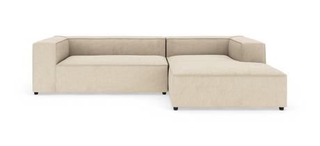 Beige modulsofa i L-form med bred chaiselong til højre.
