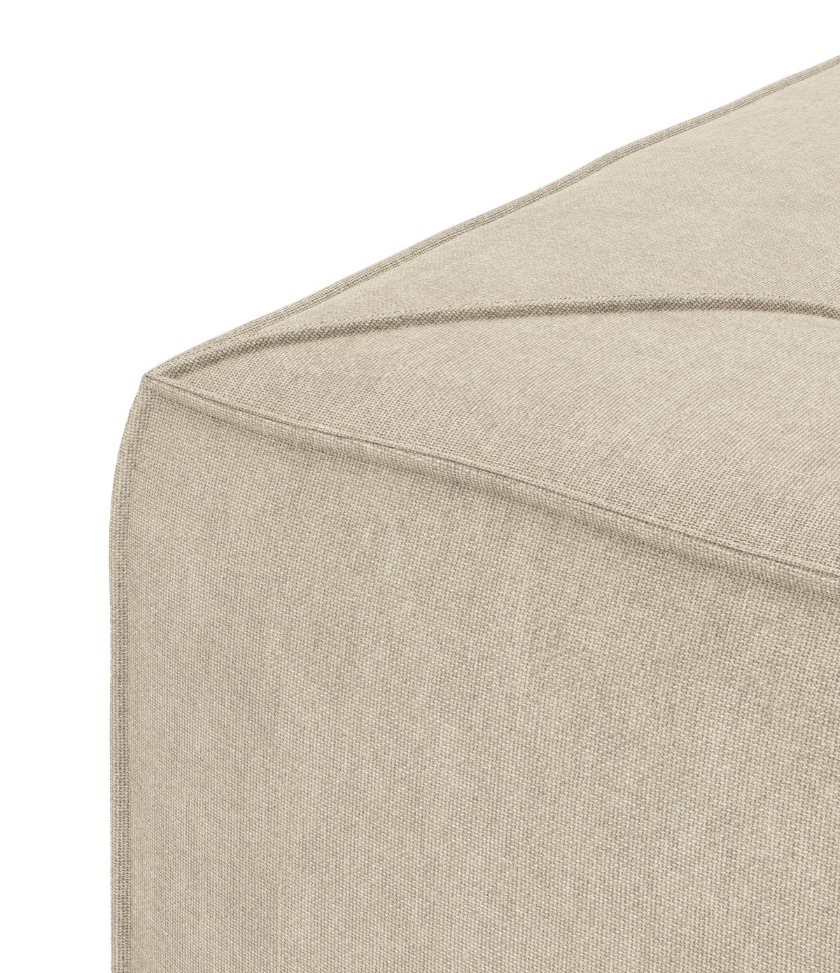 Beige stofpuf, nærbillede af hjørne med synlige diagonale syninger.