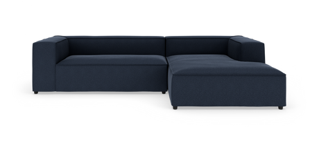 Mørkeblå modulær L-formet sofa med chaiselong til højre, lave blok-armlæn og stofbetræk, frilagt på hvid baggrund.
