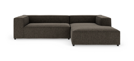 Mørkegrå modulær L‑sofa på hvid baggrund med lav ryg og bred chaiselong til højre.