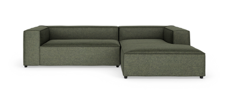 Grøn modulsofa i L‑form med chaiselong til højre, fotograferet mod hvid baggrund.