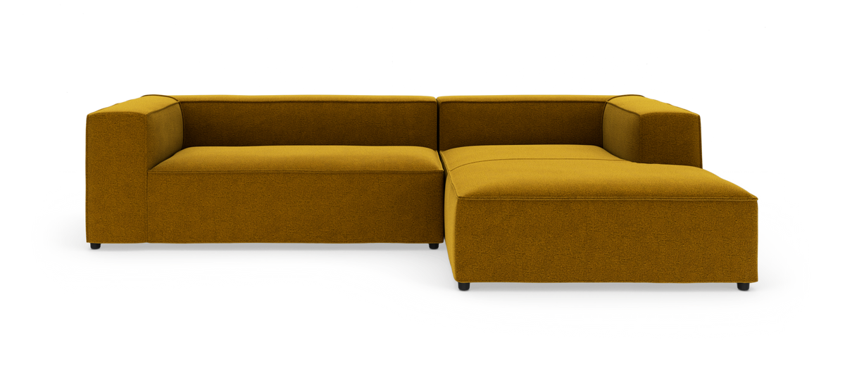 Sennepsgul L‑formet modulsofa på hvid studiobaggrund.