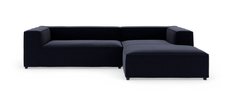 Mørkeblå L-formet modulsofa med chaiselong til højre på hvid baggrund.
