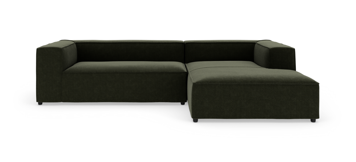 Mørkegrøn modulsofa i L‑form på hvid baggrund.