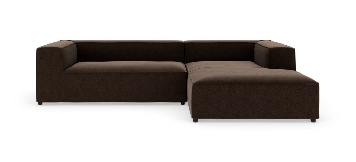 Brun L-formet modulsofa med chaiselong til højre, lav ryg og brede armlæn.