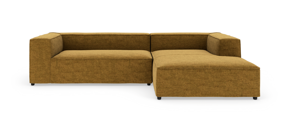 L-formet modulsofa i sennepsgul tekstil på hvid baggrund.