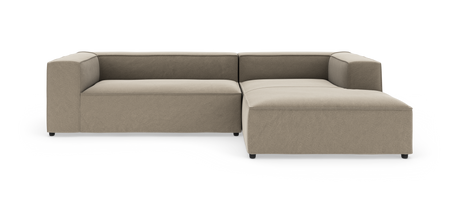 Beige L-formet modulsofa med brede blokarmlæn og højrevendt chaiselong, fotograferet mod hvid baggrund.