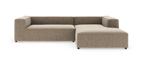 Modulsofa i L-form med brede armlæn og højre chaiselong i beige stof, frilagt på hvid baggrund.