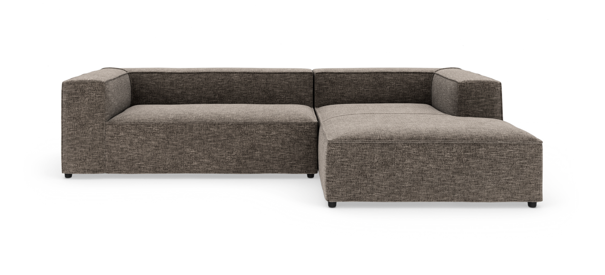 Modulsofa i L‑form med bred chaiselong i gråmeleret stof, fritstående på hvid baggrund.