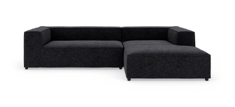 Mørkegrå L‑formet modulsofa fotograferet i studie mod hvid baggrund.
