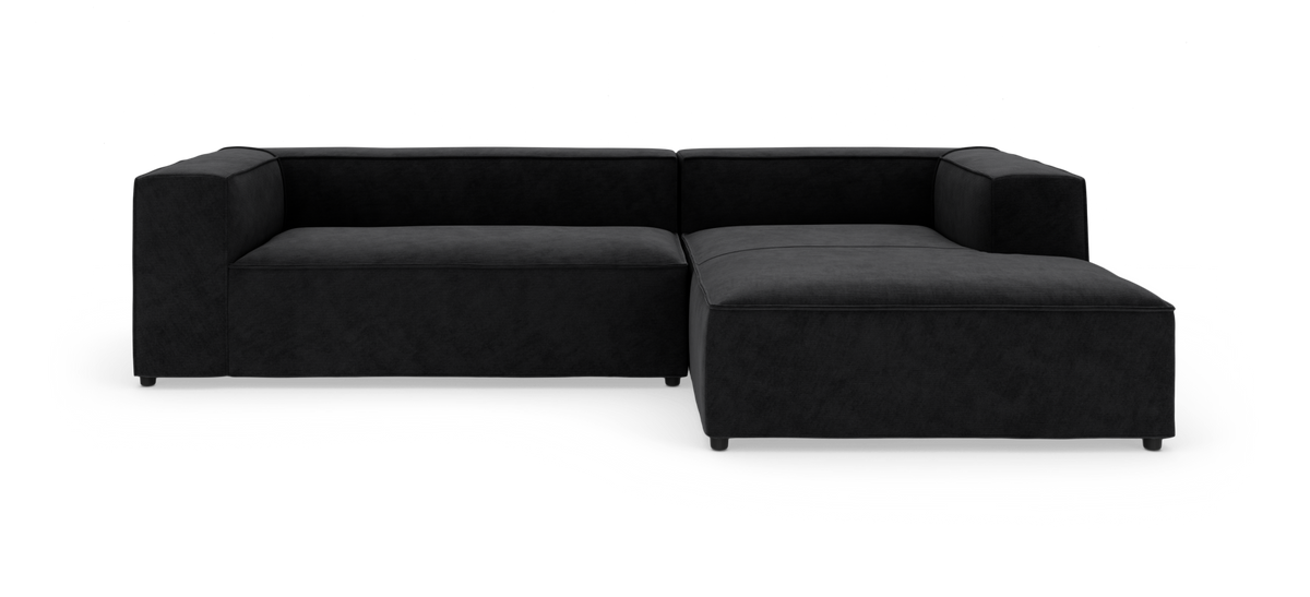 Sort modulsofa med chaiselong fotograferet i studie på hvid baggrund.