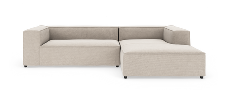 Modulsofa i beige stof med højre chaiselong, kubeformede armlæn og lav profil, frilagt på hvid baggrund.