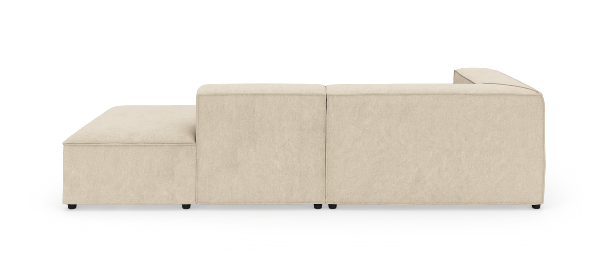 Beige modulsofa set bagfra med venstrevendt chaiselong, fotograferet i studie på hvid baggrund.