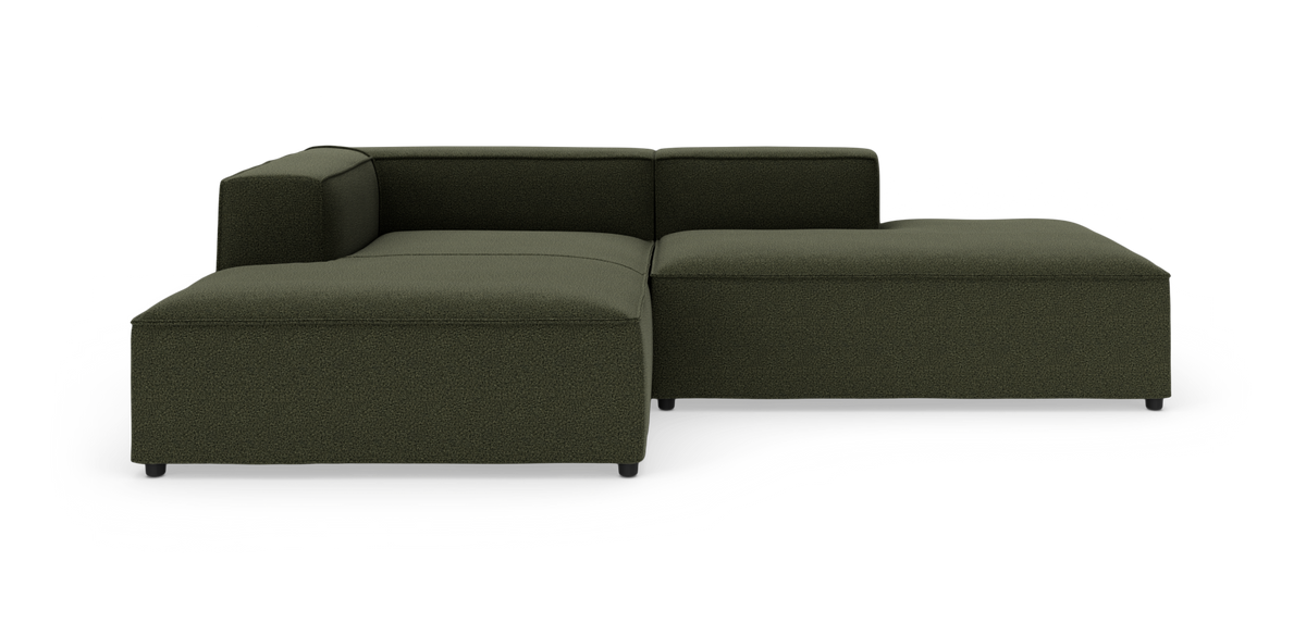 Modulær mørkegrøn hjørnesofa med chaiselong, frilagt på hvid baggrund.