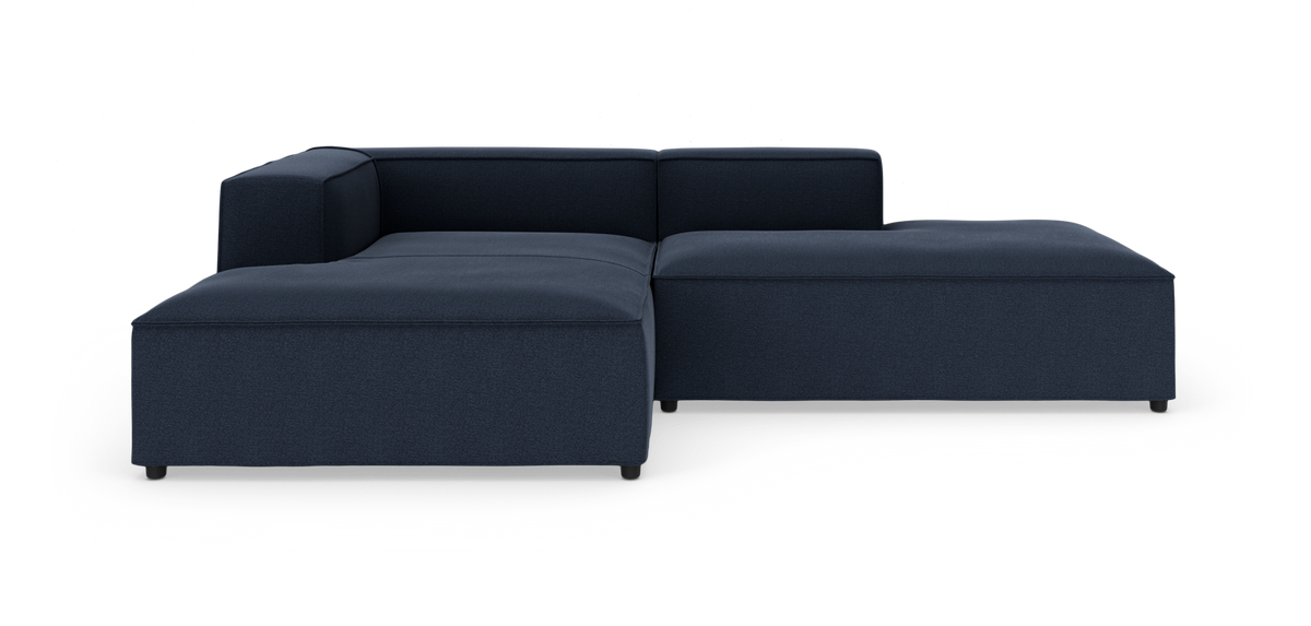 Modulær L‑formet mørkeblå stofsofa på hvid baggrund.