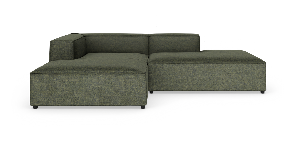 Modulær hjørnesofa i grøn tekstil med lav profil og chaiselong, frilagt på hvid baggrund.