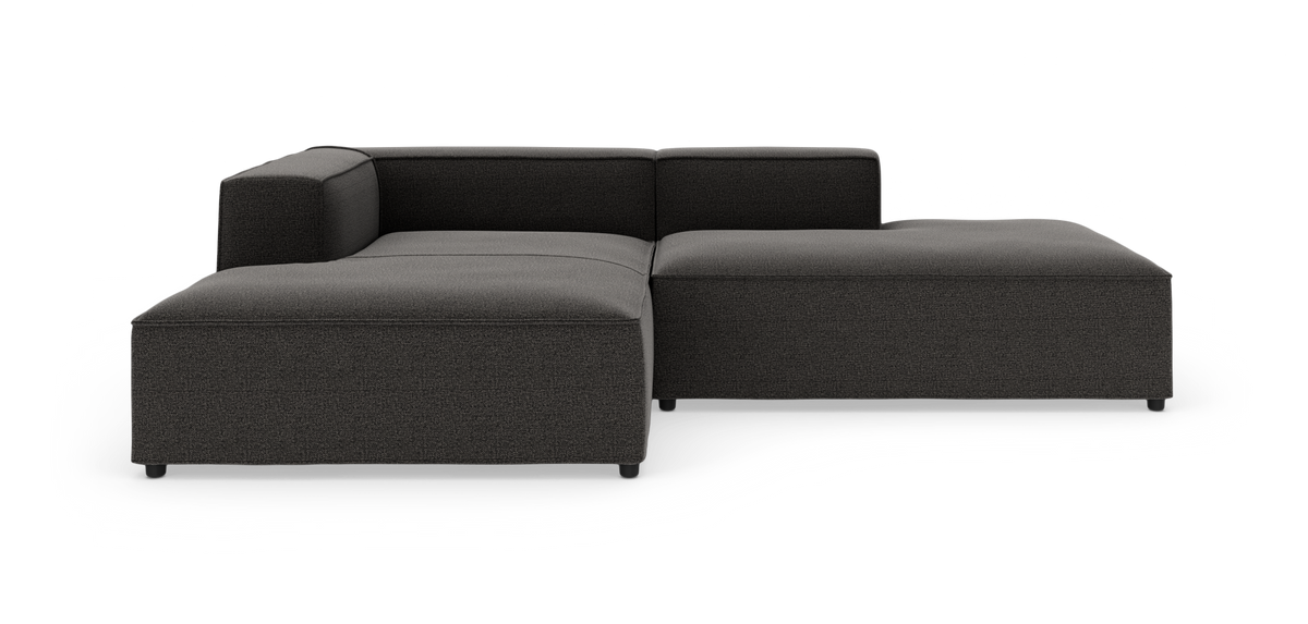 Mørkegrå modulsofa i L-form på hvid baggrund.