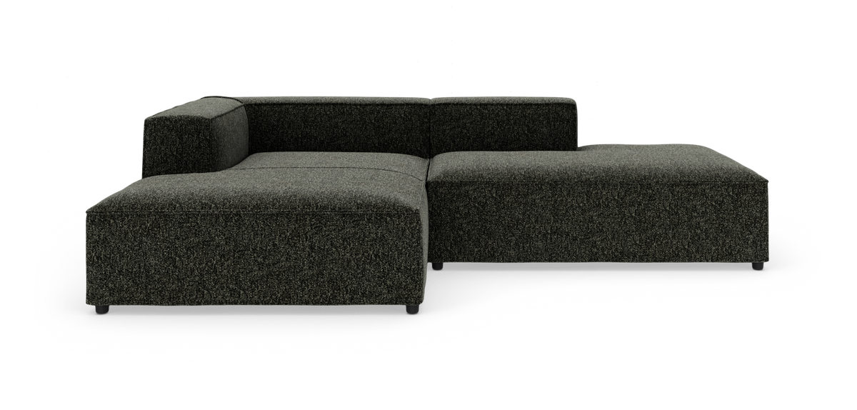 Mørkegrå L-formet modulsofa med lav ryg på hvid baggrund.