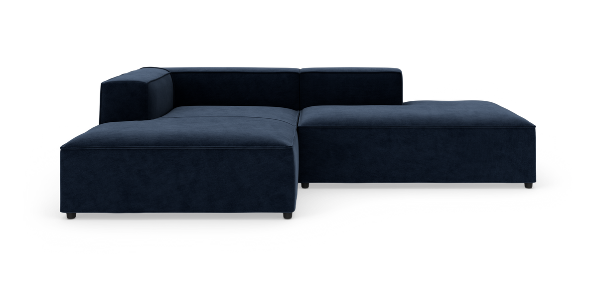 Mørkeblå modulsofa med chaiselong, fotograferet forfra i studie.
