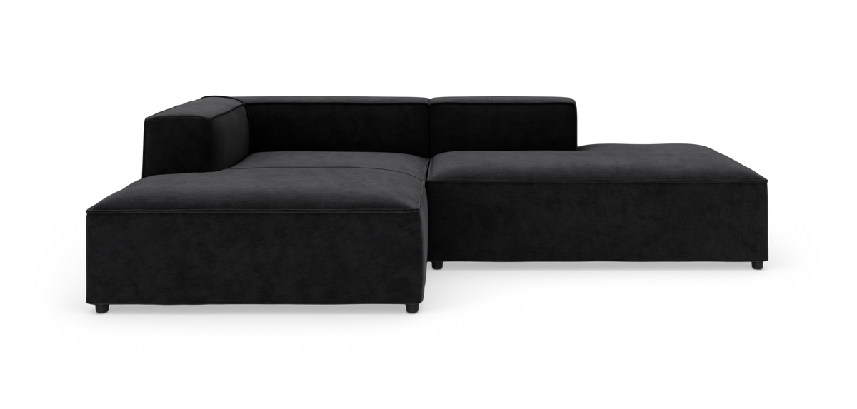 Modulsofa i sort stof med venstrehjørne og bred chaiselong, fritlagt på hvid baggrund.