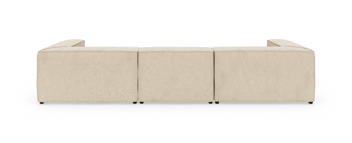 Beige modulsofa set bagfra med tre lige sektioner og åbne armlæn i begge ender.