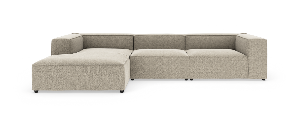 Modulær beige hjørnesofa med chaiselong, lav profil og brede armlæn på hvid baggrund.