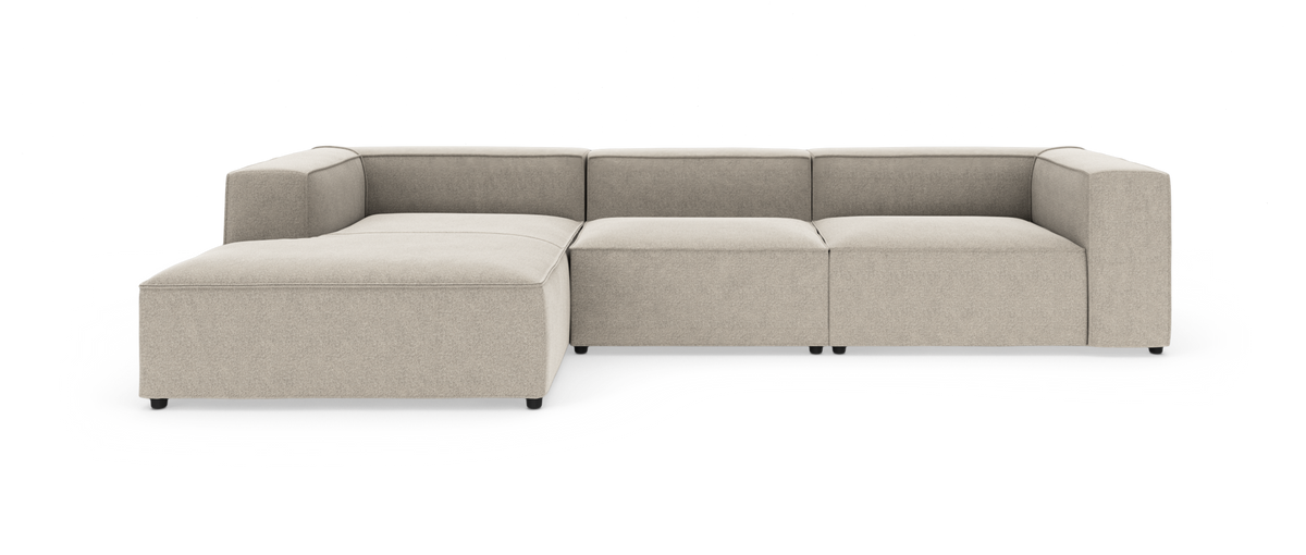Modulsofa i beige stof med venstrevendt chaiselong, lav ryg og brede armlæn; fritlagt produktbillede.