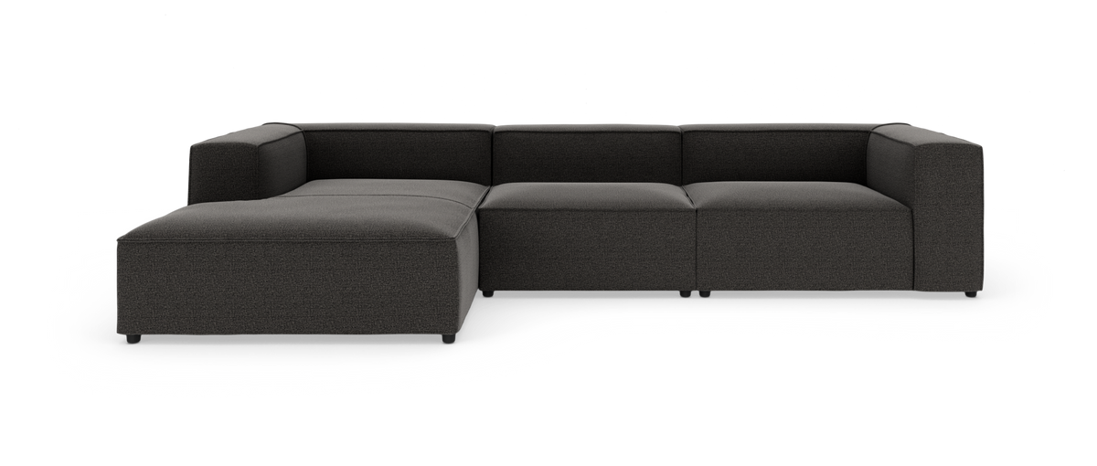 Mørkegrå modulær hjørnesofa med venstrevendt chaiselong, kubisk design, frilagt på hvid baggrund.