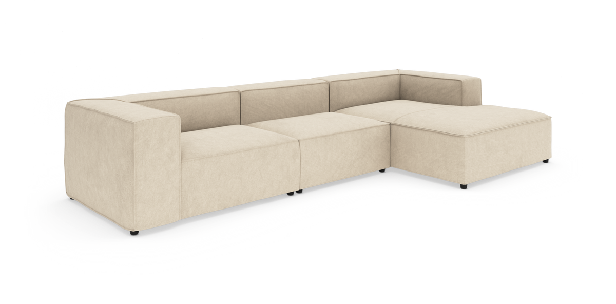 Beige modulsofa i L-form med chaiselong, moderne og lavprofil.
